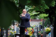 Mężczyzna grający na trąbce w czasie uroczystości żałobnej