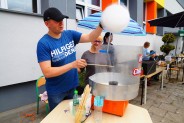 Mężczyzna w niebieskiej koszulce robi watę cukrową.