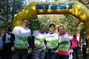Zdjęcie grupowe uczestników  Biegu Jesieni i Nordic Walking w Parku Pszczelnik na tle żółtej bramy
