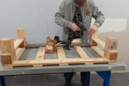 Uczeń w trakcie pracy nad ławką z palet.
