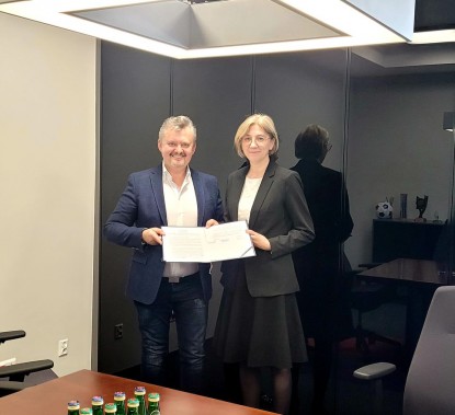Podpisana umowa w rękach dyrektor szkoły i prezesa firmy