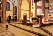 Górniczy poczet sztandarowy stojący obok księdza odprawiającego mszę.