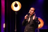 Na scenie SCK-Bytków baryton Ireneusz Miczka, ubrany na czarno, śpiewa do mirofonu. Za nim…
