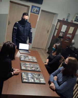 Policjant instruuje wychowawczynie. Na stole - walizki profilaktyczne.