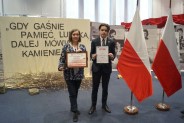 Laureat wraz z koordynator projektu na tle wystawy pokonkursowej