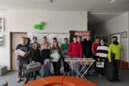 Grupa uczniów z różnymi przedmiotami w rękach ustawiła się do zdjęcia.
