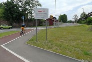 Fragment łącznika drogowego - ściezka rowerowa, po której jedzie rowerzysta, chodnik i jezdnia.…
