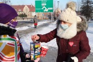 Kobieta wrzucająca datek do puszki dziewczynki