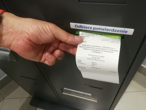 Dłoń obsługująca opłatomat.