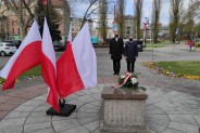Płyta pomnika, flagi państwowe, oddający hołd walczącym o wolność