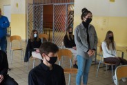 Stojąca uczennica zadaje pytanie gościowi spotkania