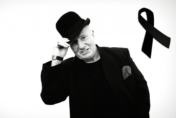 Lucjan Czerny na białym tle. Jest ubrany w czarną marynarkę. Na głowie ma kapelusz. Obok postaci…