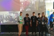 E-sportowcy podczas zawodów na tle ekranu