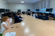 Uczestnicy warsztatów siedzą przy stole konferencyjnym.