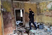 Policjant w opustoszałym, zrujnowanym budynku