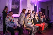 Na sali lustrzanej na krzesłach siedzą chłopcy za nimi stoją dziewczyny wszyscy z naszyjnikami…