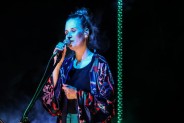 Na scenie wokalistka Mikromusic Natalia Grosiak. Ma na sobie kolorowe kimono i czarną koszulkę.…