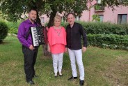 Troje ludzi - dwóch mężczyzn i jedna kobieta na tle drzewa i zielonej trawy. Jeden z mężczyzn…