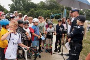 Policjanci zadają konkursowe pytania młodzieży na skateparku.