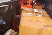 Dziewczyny umieszczają paczki z darami na tylnym siedzeniu samochodu