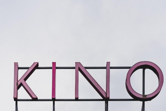 Neon kino w kolorze różowym, na białym tle