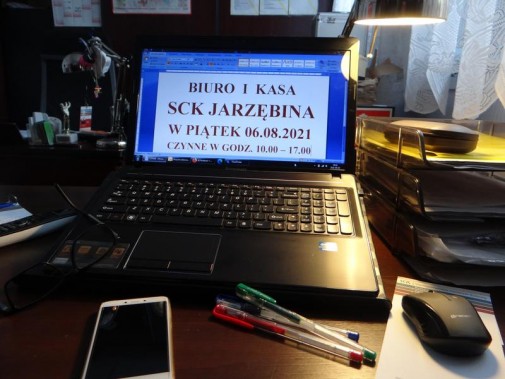 Wnętrze biura. Na pierwszym planie biurko z laptopem