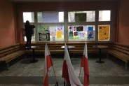 Uczennica umieszczająca plakat na oknie szkoły