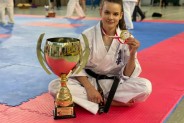 Daria Dobkowska - Szefer siedzi na tatami z pucharem i prezentuje złoty medal