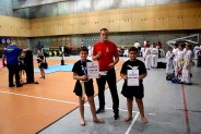Trener Dawid Latosik wraz z 9-letnim Szymonem i 10 letnim Fabianem.Zawodnicy w czarnym stroju…