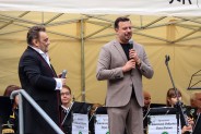 Na tle górniczej orkiestry stoi Prezydent m. Siemianowice - Pan Rafał piech z mikrofonem w ręce.…
