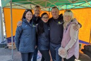 Pięć osób organizatorzy Biegu Jesieni i Nordic Walking w Biurze Zawodów na tle żółto zielonego…