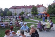 Widzowie koncertu na planie pierwszym. W tle scena z artystami