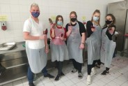 Chłopak oraz cztery dziewczyny pozujący do zdjęcia w maseczkach