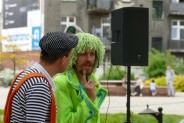 Widok na dwóch aktorów podczas spektaklu. W tle Rynek Miejski