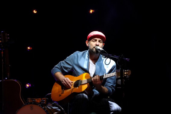 Siedzący mężczyzna z gitarą