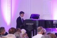 Pianista Rafał Gudyka przy czarnym fortepianie Petrof na scenie SCK Zameczek
