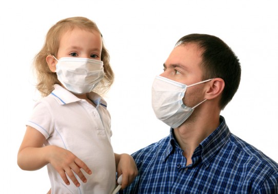 Ojcec z córeczkąa na ręku w maskach ochronnych na twarzy
