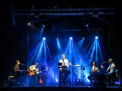 Widok na scenie. Na scenie zespół Albo i Nie. Muzycy ubrani w białe koszule i czarne krawaty…