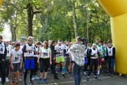 Zdjęcie grupowe  uczestników  Biegu Jesieni i Nordic Walking w Parku Pszczelnik na tle żółtej bramy