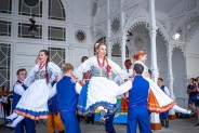 Panowie unoszą panie na przedramionach podczas tańca