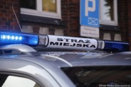 Zespolona lampa ledowa o barwie niebieskiej z podświetlonym napisem Straż Miejska