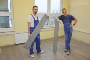 Uczniowie wykonujący montaż paneli podłogowych.
