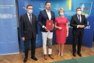 Uczestnicy uroczystego podpisania umów pozują do zdjęcia pamiątkowego