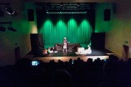 Widok z góry na salę Parku Tradycji. Na zielonym tle sceny dzieci z grupy teatralnej Śrubki…