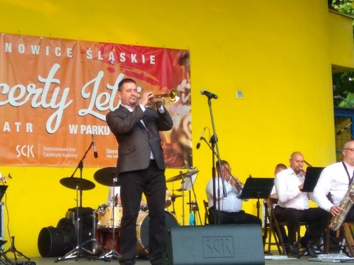 Na scenie, na żóltym tle, muzyk big bandu Siemion Band - Jarosław Spałek